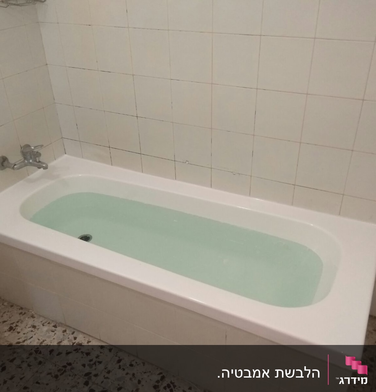 אמבטיה עם מים, אריחי קיר לבנים וברז מתכת
